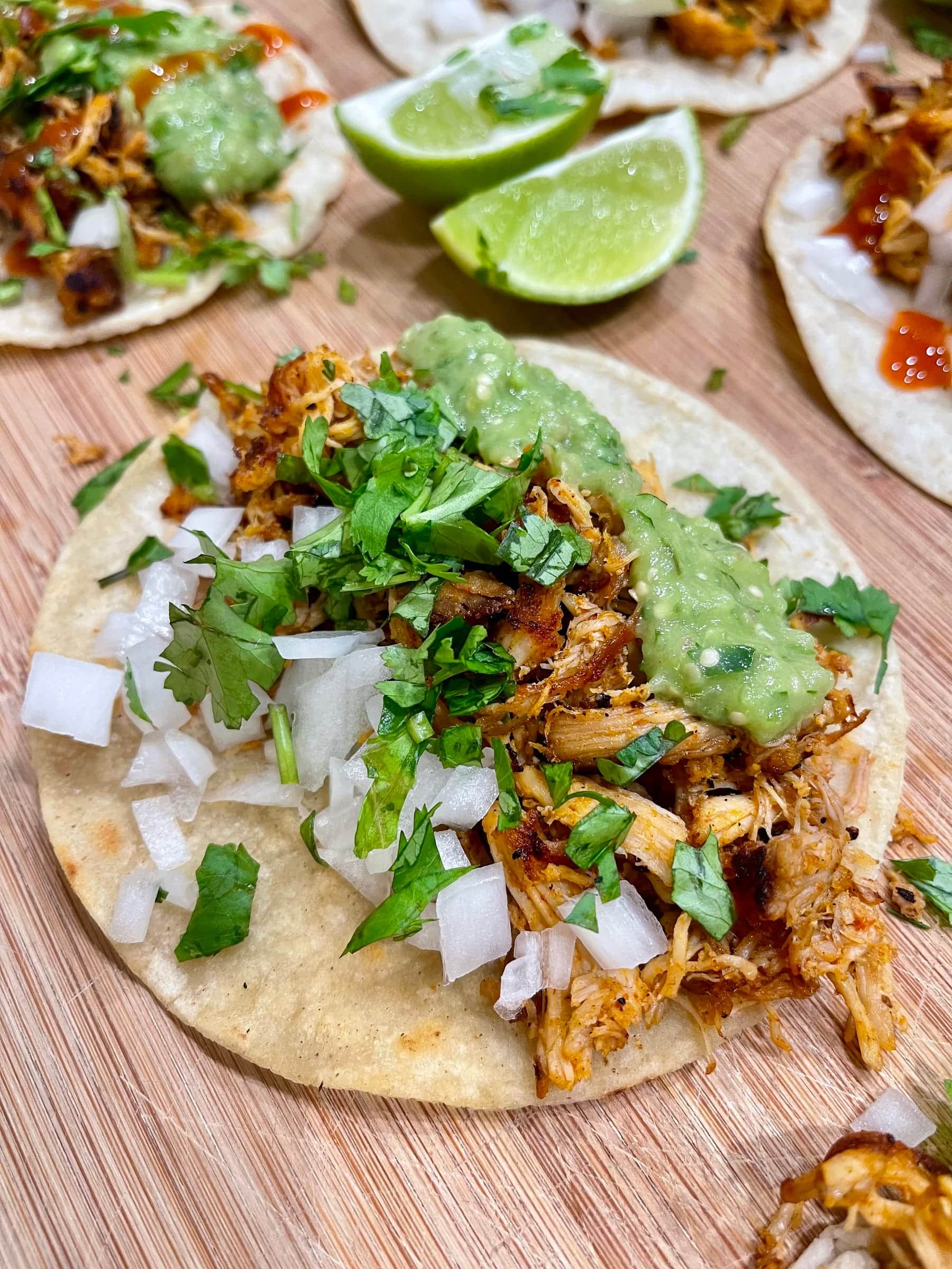 Carnitas taco with salsa verde, onion, and cilantro