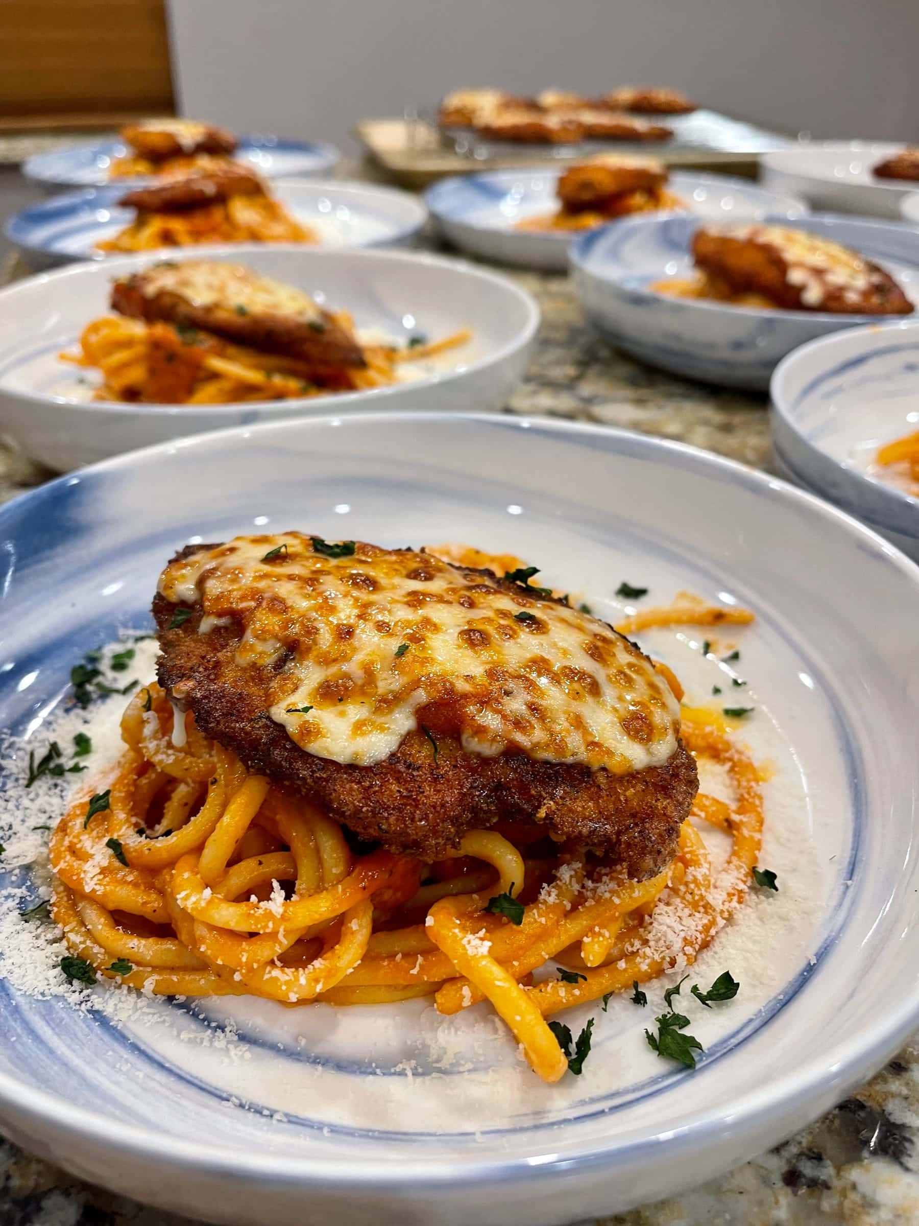 Chicken parmesan over bucatini with marinara