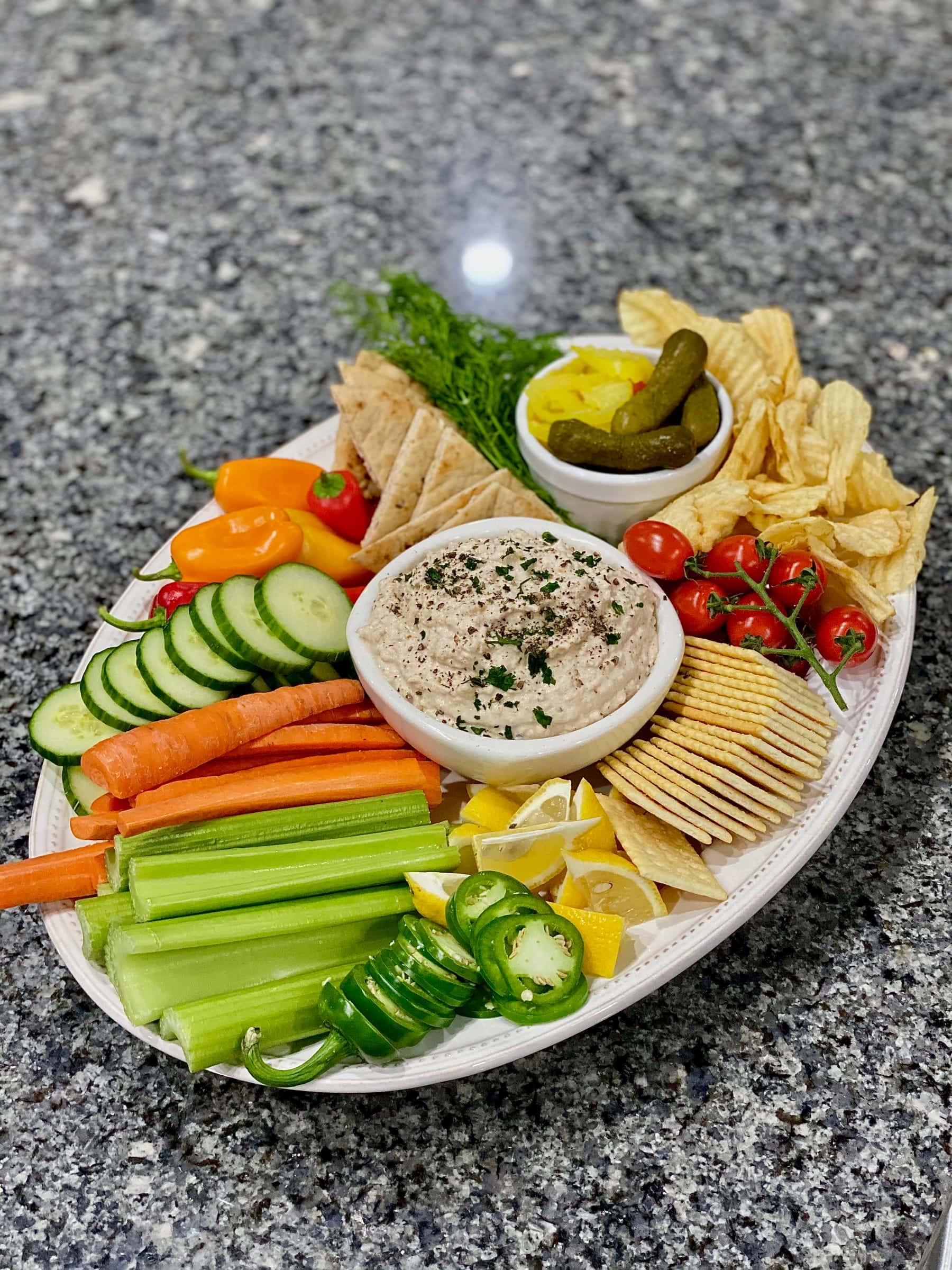 Crudité and dip platter with chips, pickles, and vegetables