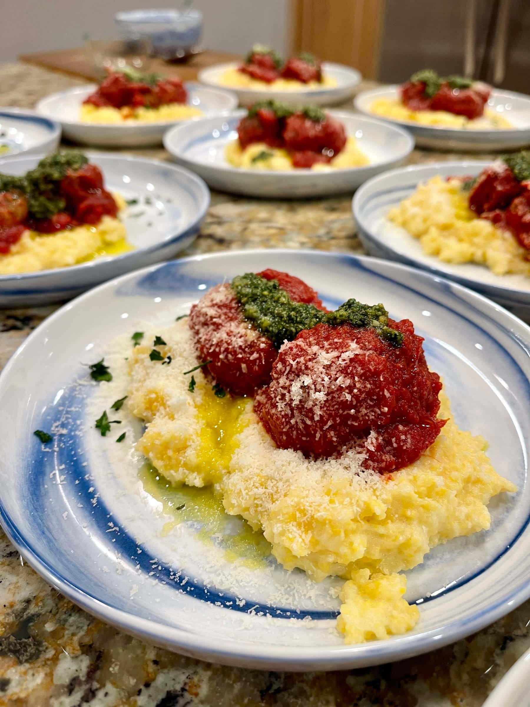 Meatballs over creamy polenta with pesto and parmesan